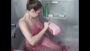 Amateur brunette squats in bathtub to pour strawberry milk down her tits and ass